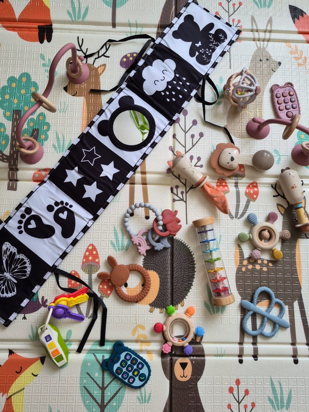 Éveil sensoriel — hochets et jouets de motricité fine sur le tapis d'activités